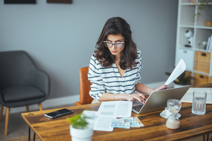 A woman calculating capital gains tax on the sale of a home.