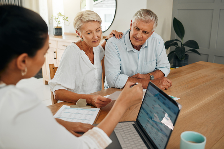 A couple sits down with their financial advisor to discuss how diversification reduces risk for their investment portfolio.